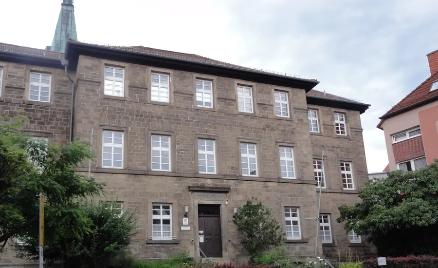 Dreigeschossiges Amtsgerichtsgebäude aus hellem Naturstein mit Sprossenfenstern und Walmdach
