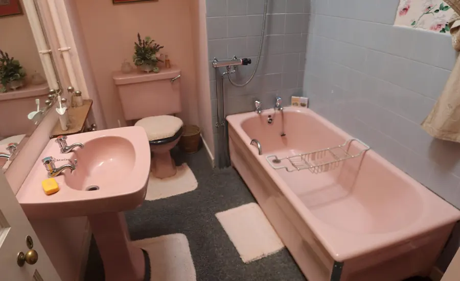 Historisches Badezimmer im Skaill House mit rosafarbenem Waschbecken, WC und Badewanne