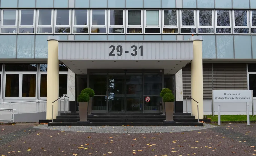 Eingang eines Behördengebäudes mit der Hausnummer 29-31, Glasvordach und einem Hinweisschild neben der Tür