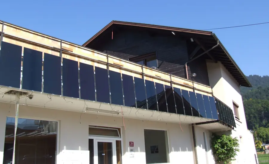 Dunkle Photovoltaikmodule an der Balkonbrüstung eines Wohnhauses