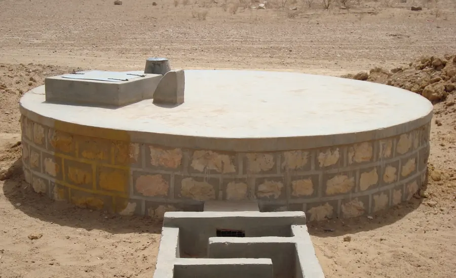 Runde Betonzisterne mit Deckel und Zulaufschacht auf einer Baustelle