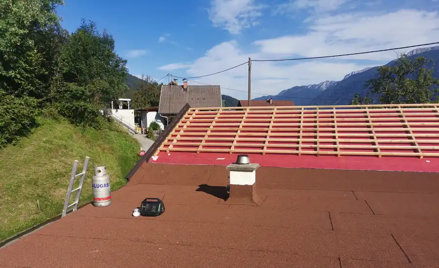 Dachfläche mit roter Unterdeckbahn und montierten Dachlatten