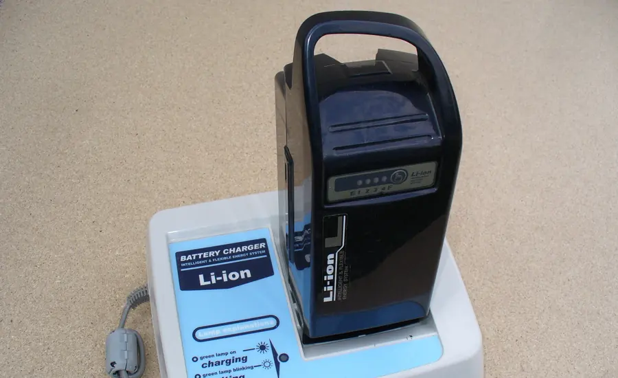 Lithium-Ionen-Akku eines Pedelecs in einer weißen Ladestation auf einer Tischplatte