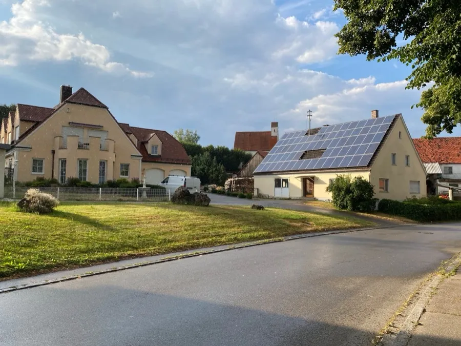 Einfamilienhaus mit Photovoltaikmodulen auf dem Satteldach an einer Dorfstraße in Aichach