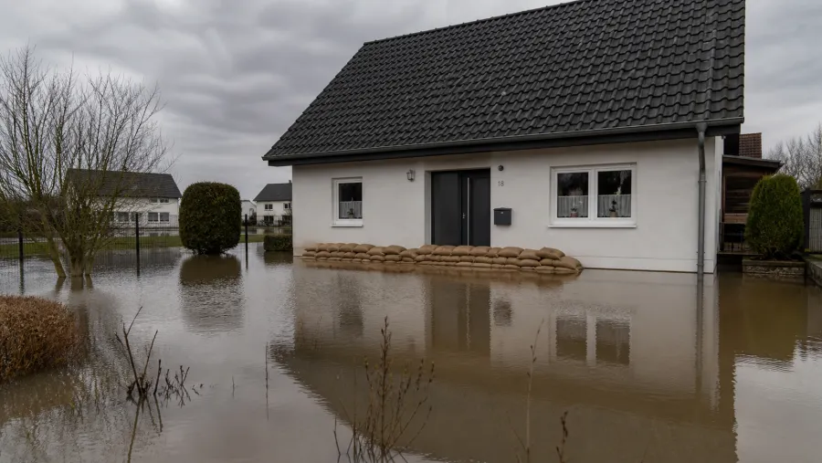 Wohnhaus mit Sandsäcken im Hochwasser – Debatte um die Elementarschaden-Pflichtversicherung