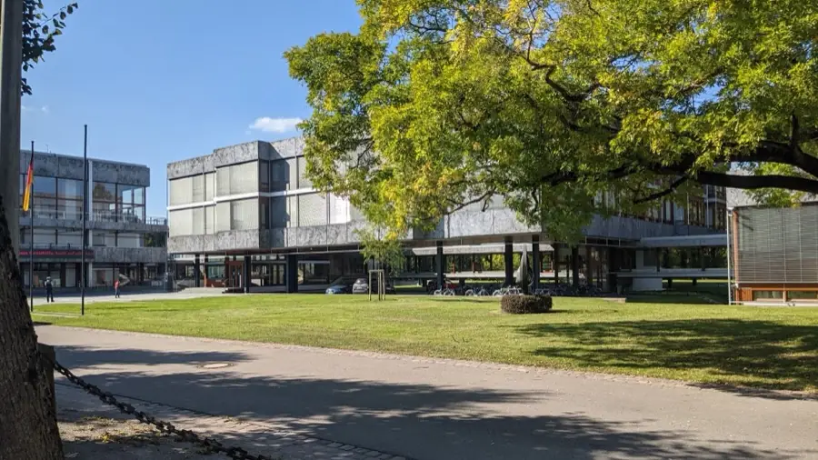 Gebäude des Bundesverfassungsgerichts in Karlsruhe mit Fahne und Laubbaum