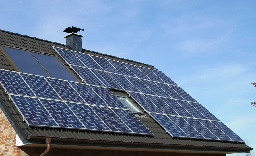 Photovoltaikmodule auf einem Ziegeldach vor blauem Himmel