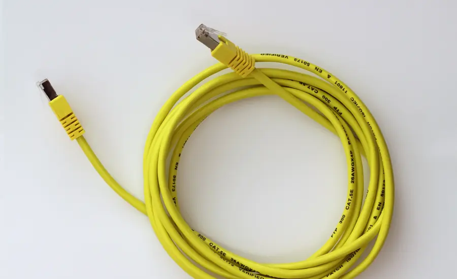 Aufgerolltes gelbes Netzwerkkabel mit zwei RJ45-Steckern