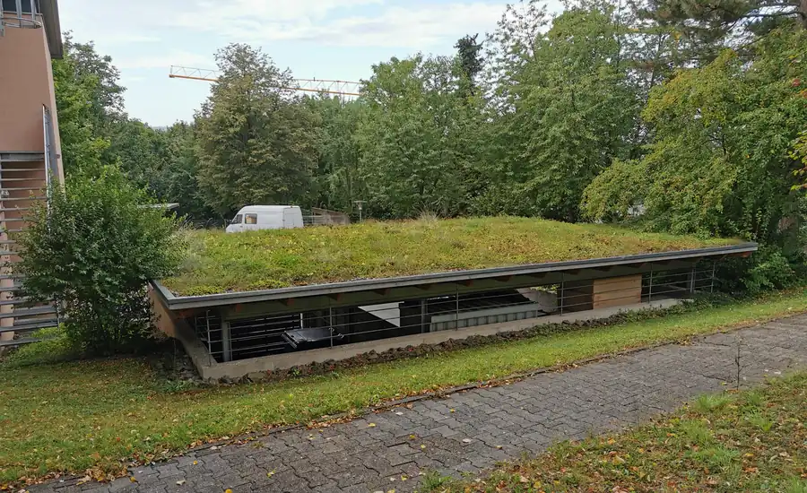 Carport mit begrüntem Flachdach an einem Hang