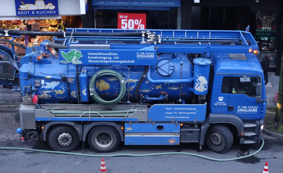 Blauer Kanalreinigungs-Lkw mit Schlauchhaspel an einer Straße