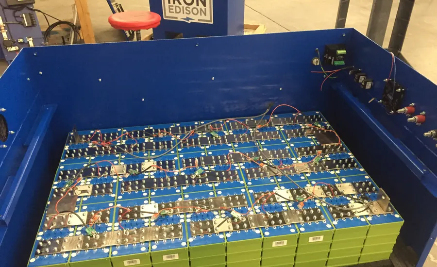 Lithium-Eisenphosphat-Zellen in einem blauen Rahmen, in Reihe verschaltet mit Zellverbindern und Messleitungen