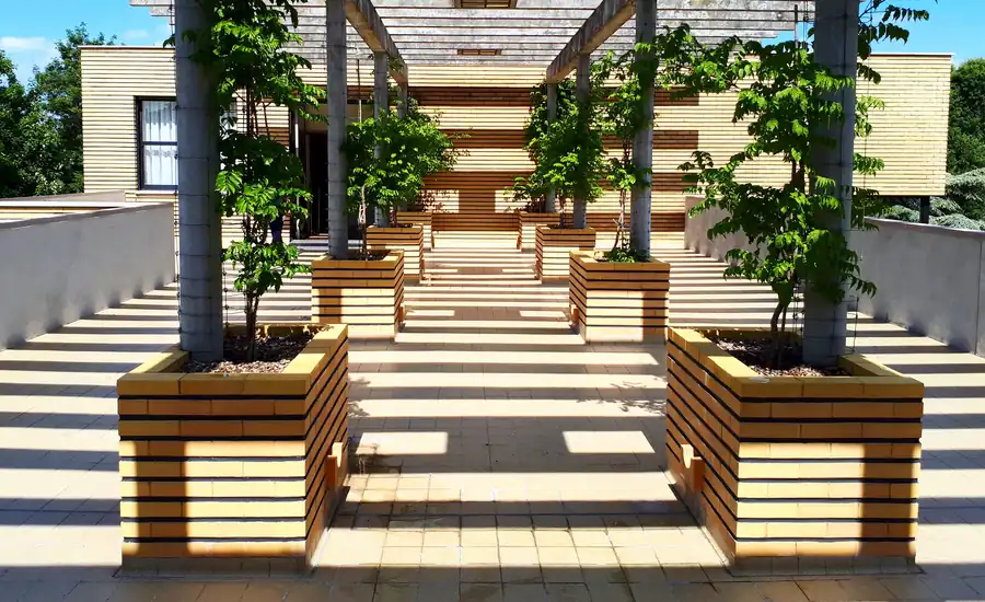Holzpergola über einer Terrasse mit bepflanzten Holzkübeln