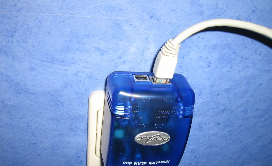 Blauer Powerline-Adapter in einer Wandsteckdose mit angestecktem Netzwerkkabel
