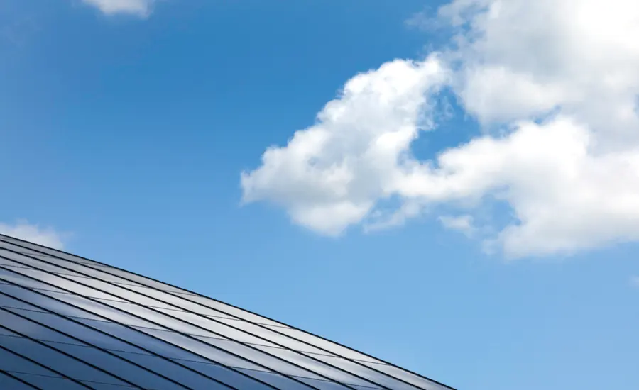 Photovoltaikmodule auf einem Hausdach vor blauem Himmel