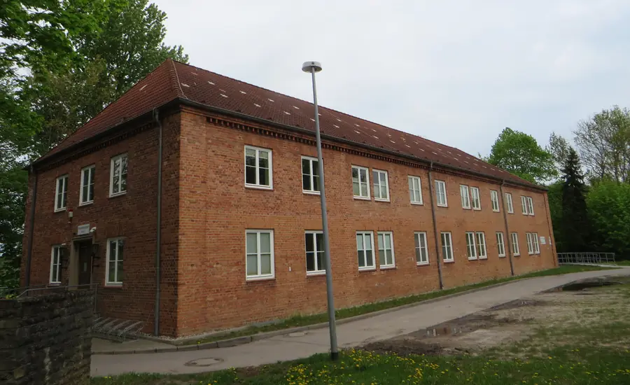 Langgestrecktes zweigeschossiges Backsteingebäude des Grundbuchamts am Amtsgericht Güstrow mit rotem Ziegeldach