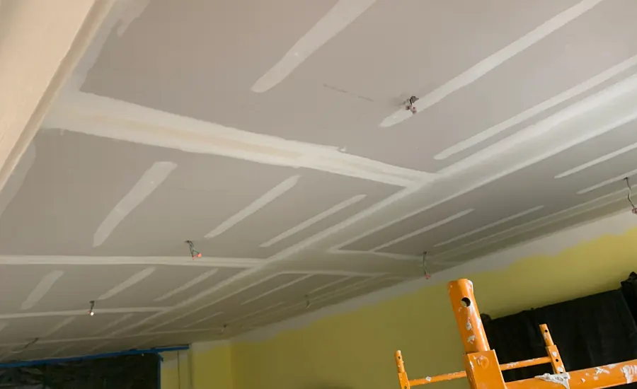 Abgehängte Schallschutzdecke aus Gipskarton mit sichtbaren Plattenstößen in einem Wohnraum