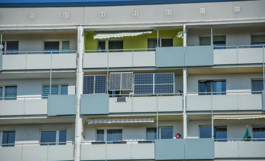 Zwei Solarmodule an der Balkonbrüstung eines Plattenbaus
