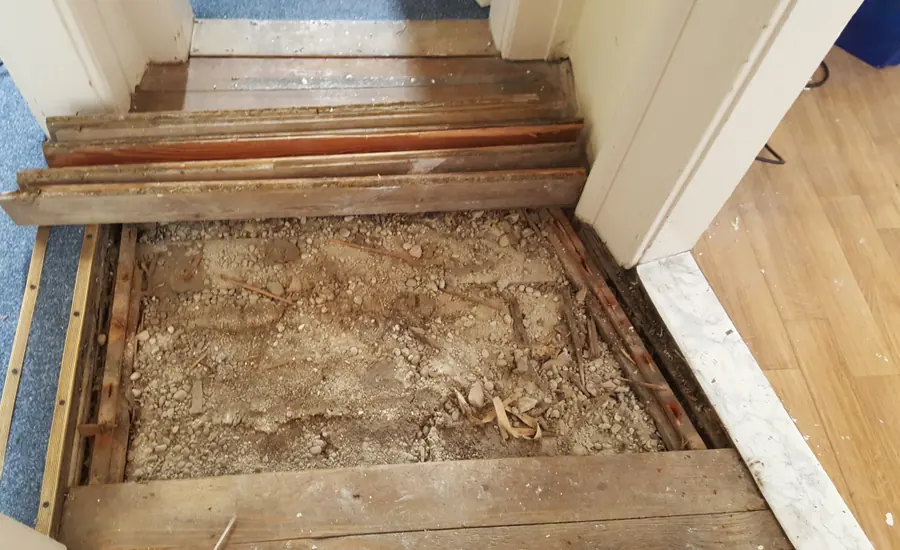 Geöffneter Holzdielenboden in einem Wohnhaus von 1905: Zwischen den Deckenbalken liegt eine aufgeschüttete Füllung auf dem Fehlboden