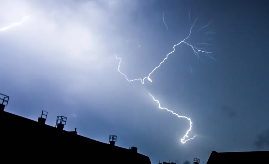 Blitz über den Dächern von Wohnhäusern bei Gewitter