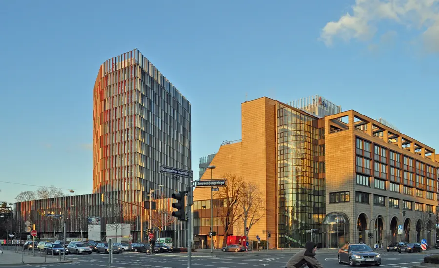 Hochhaus Westarkade der KfW-Zentrale in Frankfurt am Main mit farbiger Lamellenfassade, rechts daneben ein älterer KfW-Bau an der Kreuzung Senckenberganlage