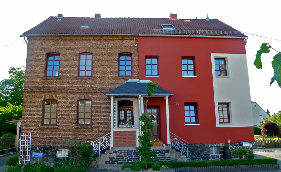 Altbaufassade, zur Hälfte mit einem Wärmedämmverbundsystem verkleidet