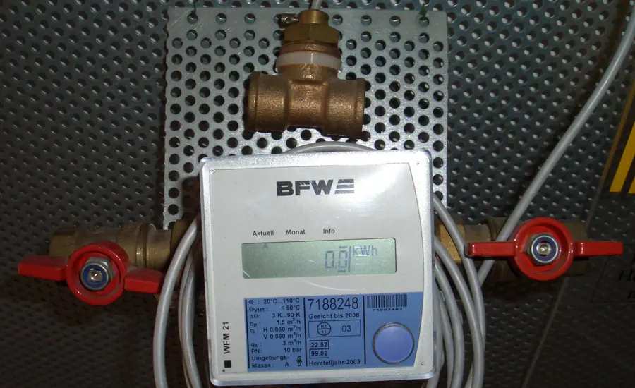 Elektronischer Wärmezähler mit Display zwischen zwei roten Absperrhähnen