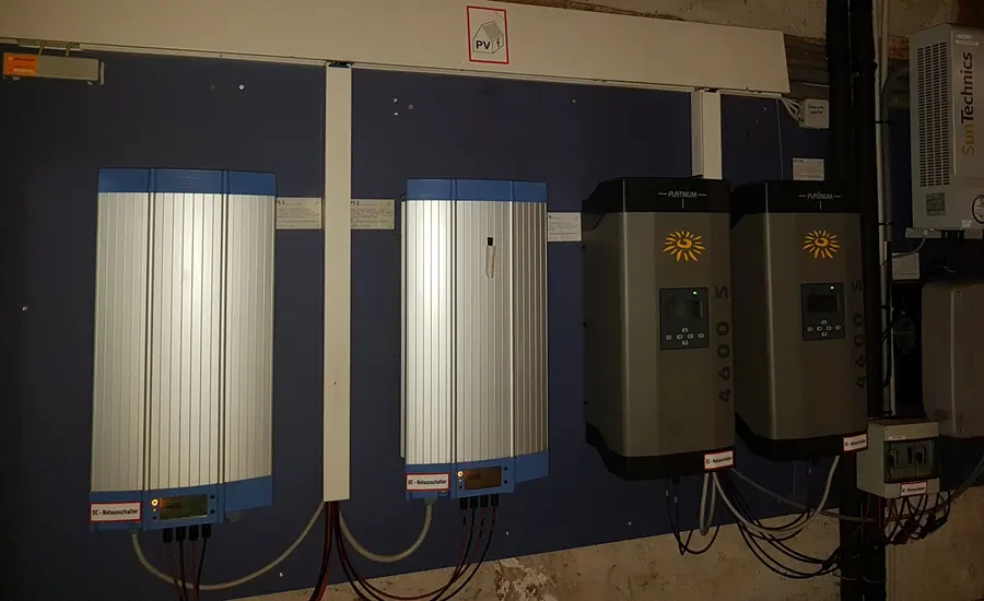 Zwei wandmontierte Wechselrichter einer Photovoltaikanlage mit Anschlussleitungen