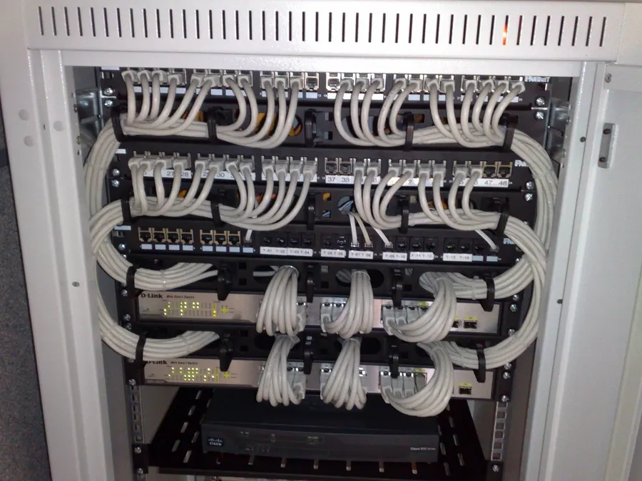 Netzwerkschrank mit Patchpanels, Switches und sauber geführten hellen Patchkabeln