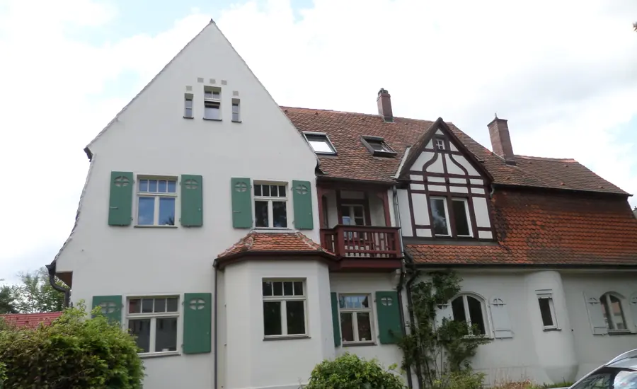 Wohnhaus, dessen eine Hälfte weiß verputzt und dessen andere Hälfte mit Fachwerk und Ziegeln verkleidet ist